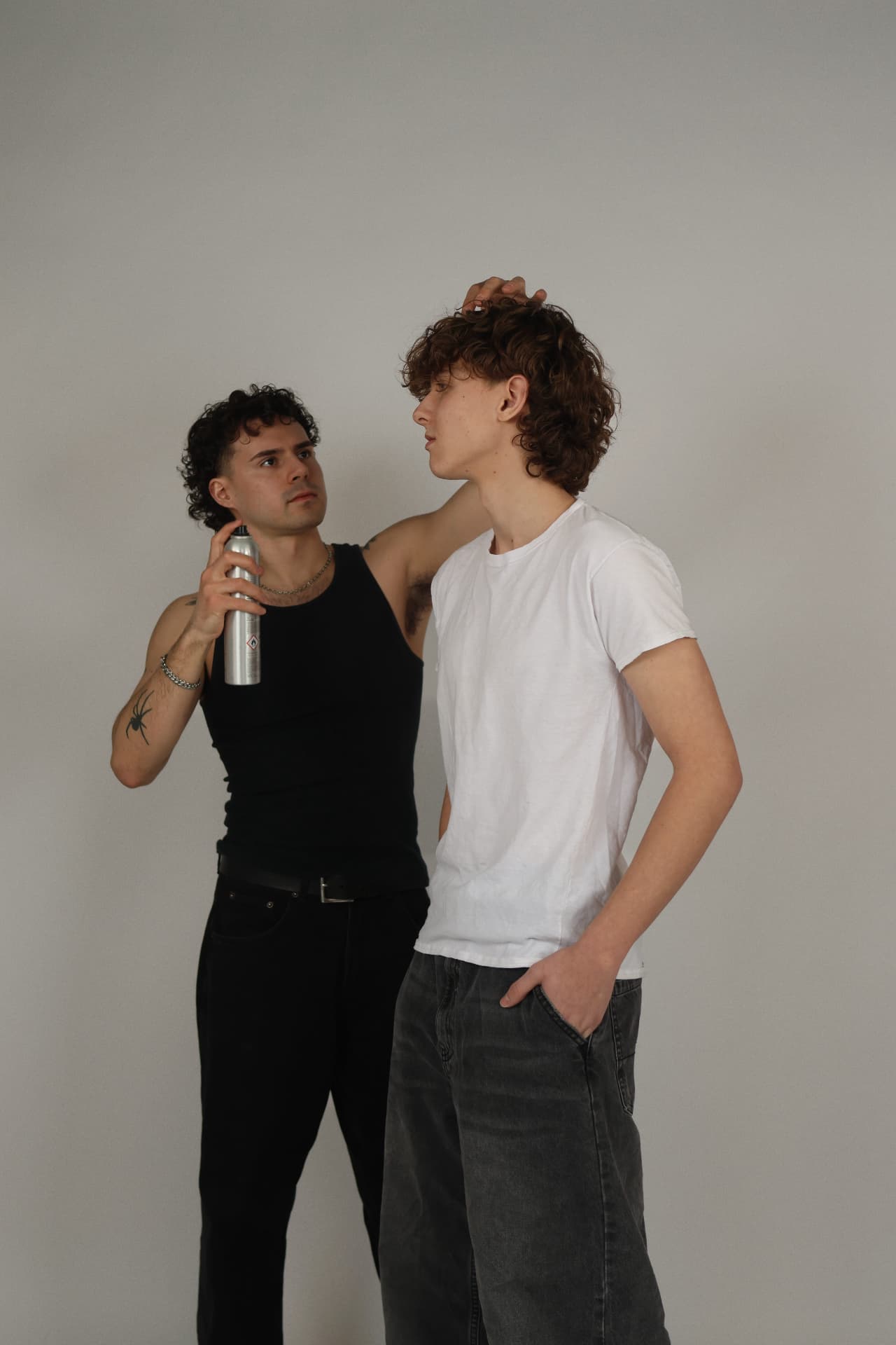Hendrixx styling a client's curly cut in the studio