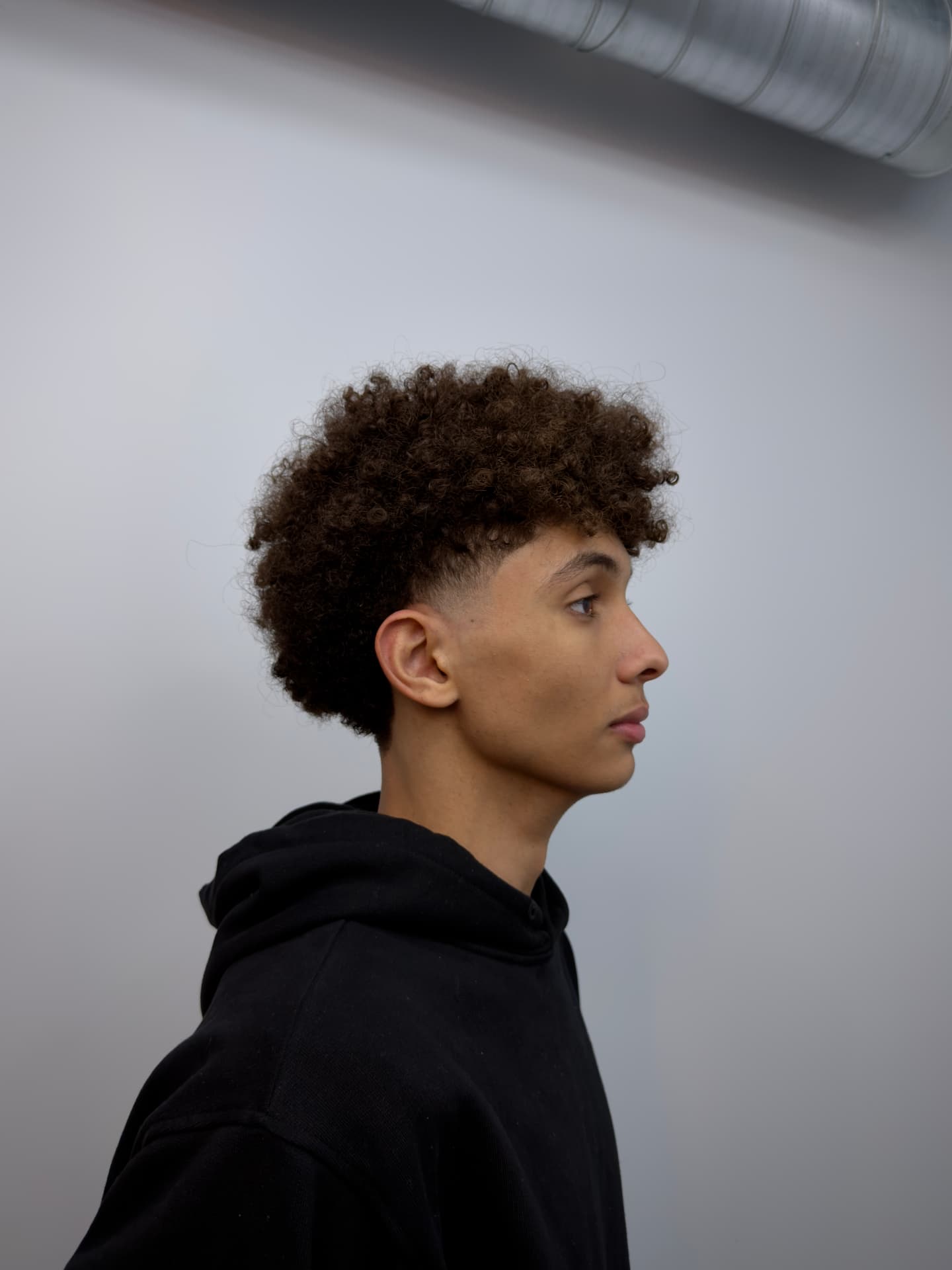Men's curly taper fade with defined natural texture